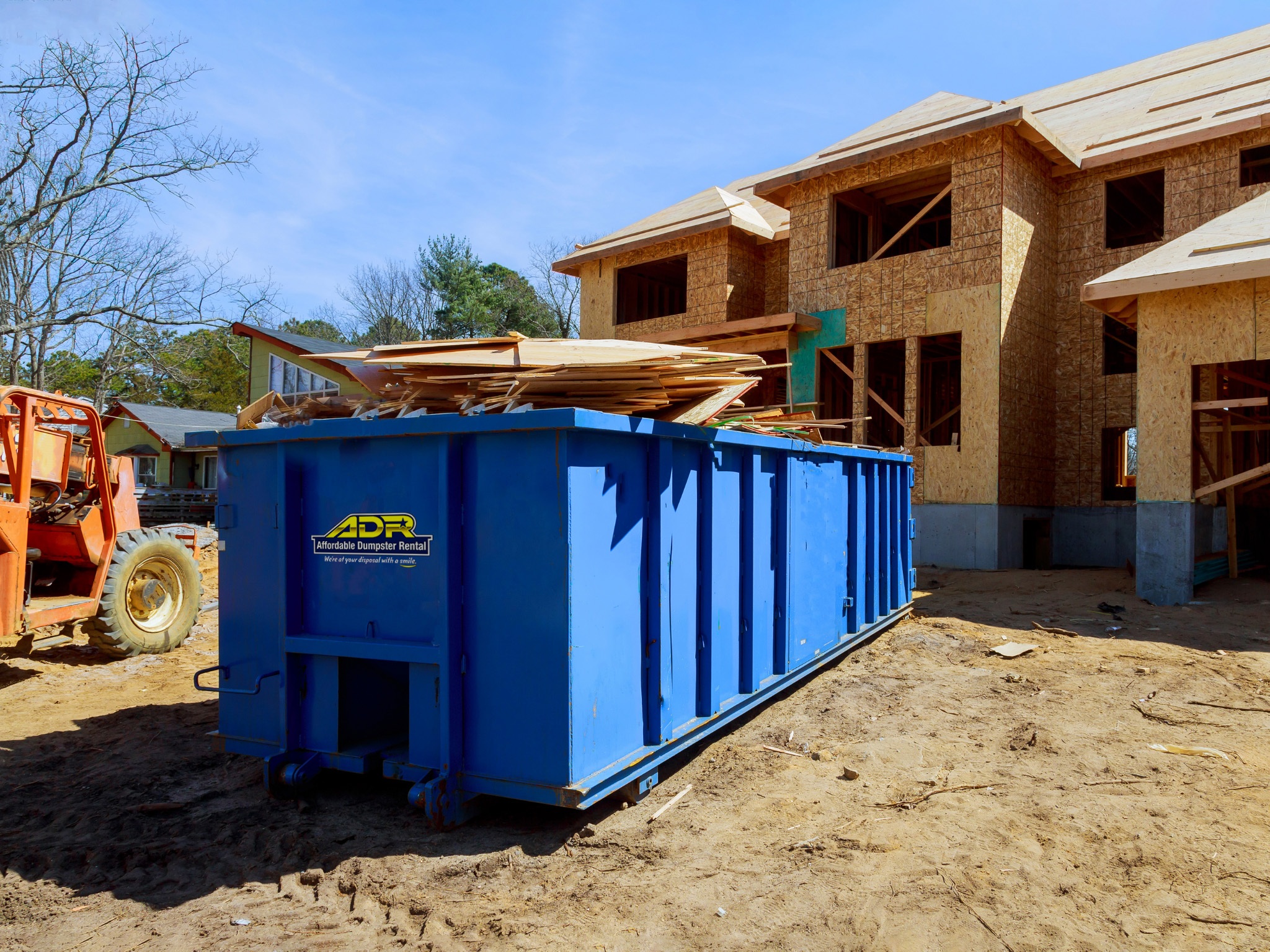 Roll off dumpster rental in front of a new construction home for construction debris and waste disposal